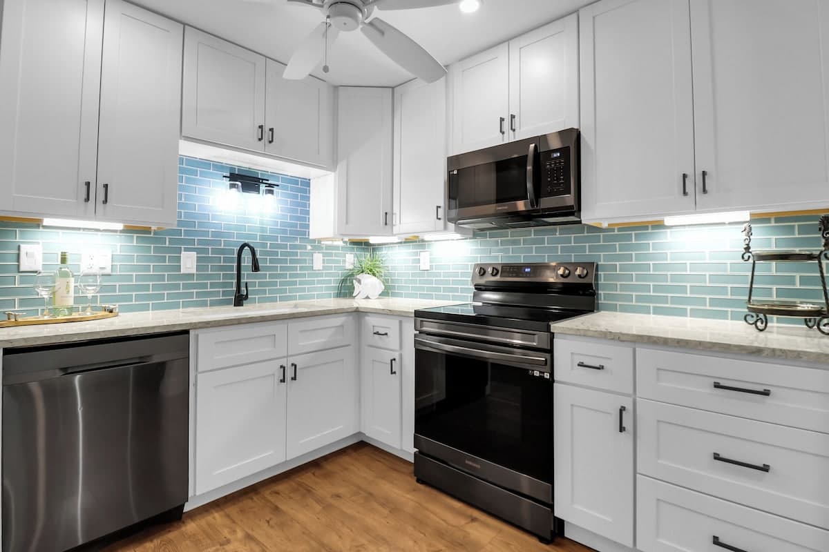 Stocked kitchen with quartz countertops and Samsung black stainless appliances