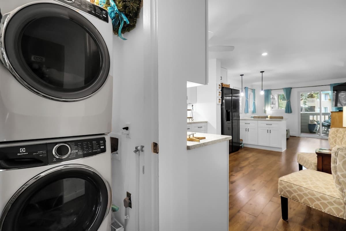 In-unit laundry room with stacked full-size washer and dryer